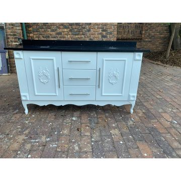 White double vanity, black galaxy top, embellished doors and silver/black bar handles.